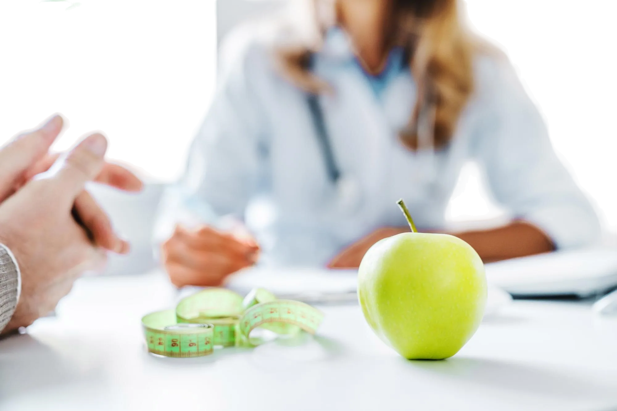 Victoria dietician giving a consult with the focus on a green apple and tape measure