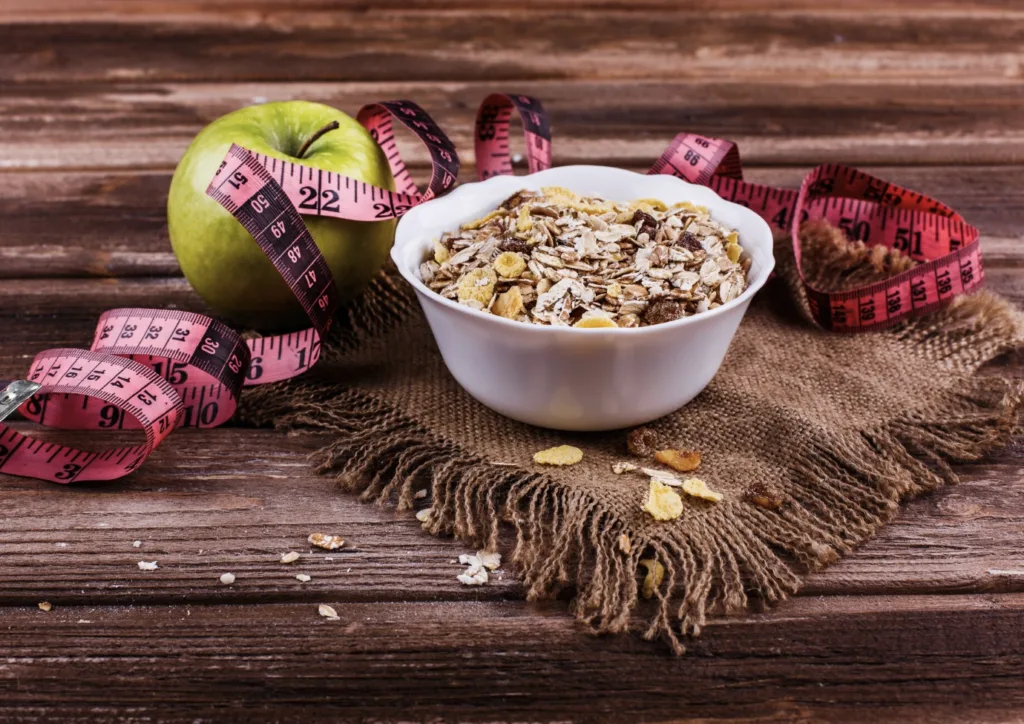High-fiber cereal with apple and measuring tape, representing fiber intake for weight loss and healthy eating