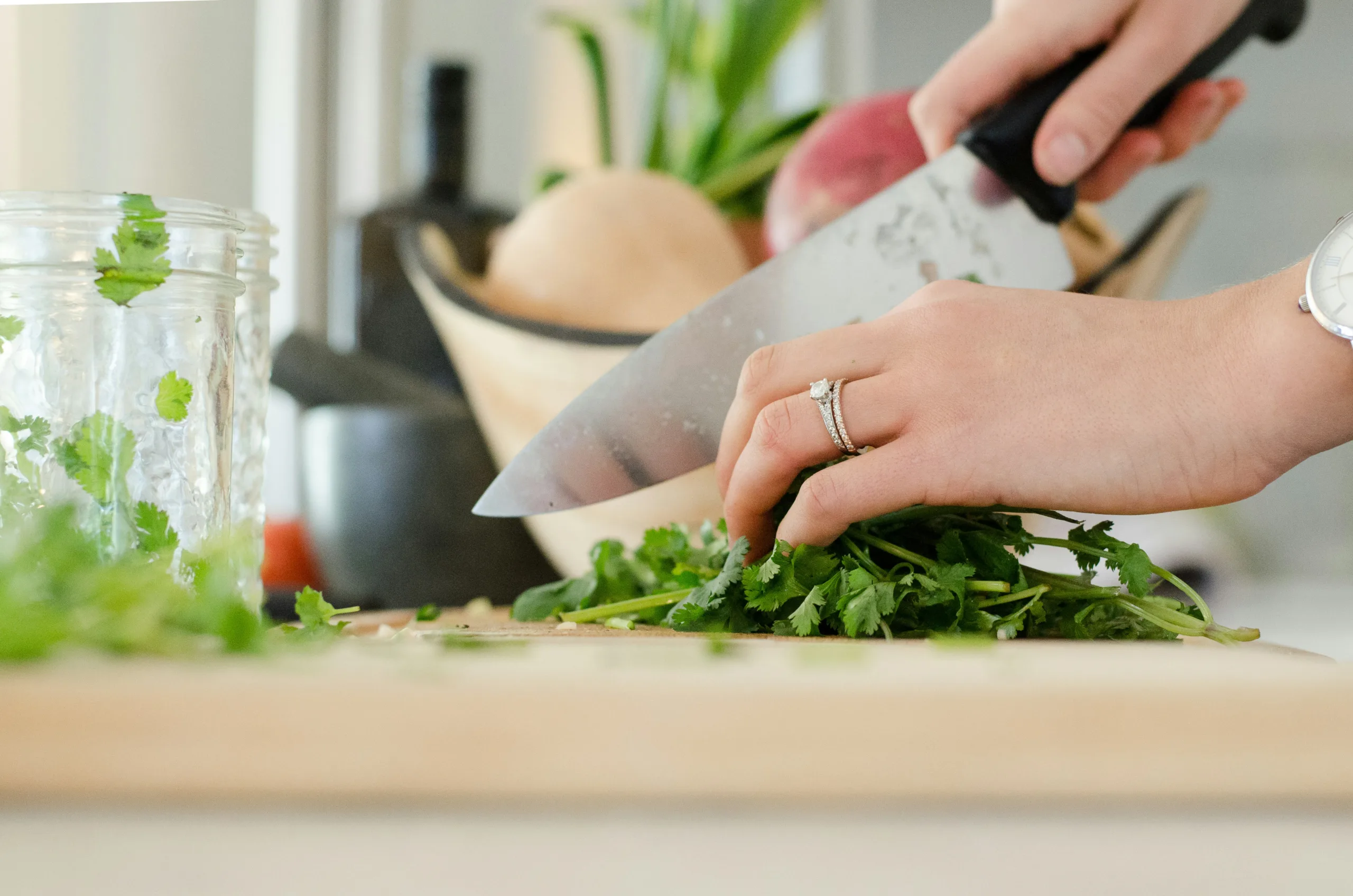 Hands chopping fresh herbs with a kitchen knife
